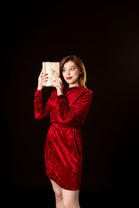 Portrait of a beautiful young woman against black background