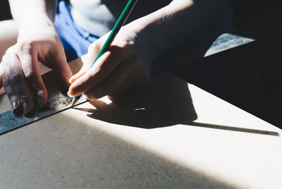 Midsection of person holding paper with text on table