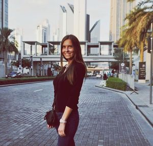 Portrait of young woman standing in park