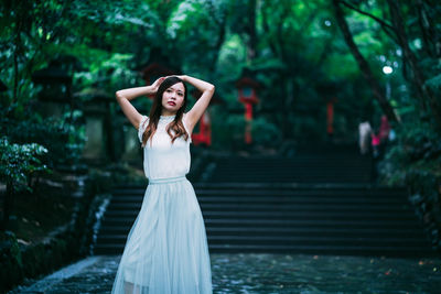 Portrait of woman standing by tree