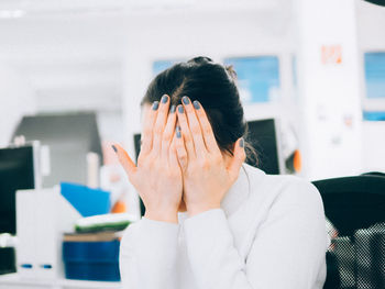 Woman with gray nail polish covering face