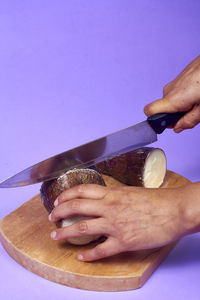 Cropped hand of woman holding drink on table