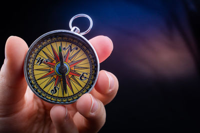 Cropped hand of person holding navigational compass