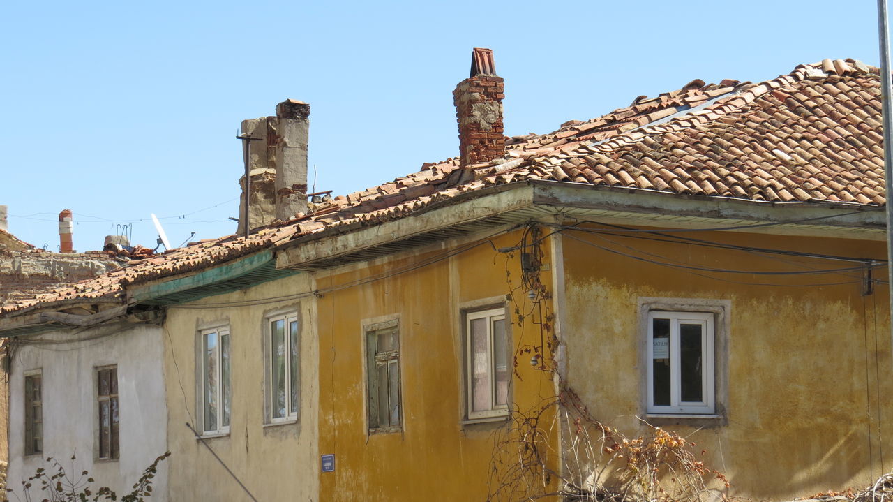 building exterior, architecture, built structure, clear sky, low angle view, window, house, roof, residential structure, residential building, exterior, history, old, day, outdoors, sky, facade, blue, sunlight, building