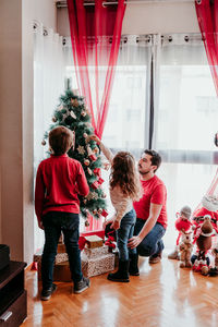 Family decorating christmas tree at home