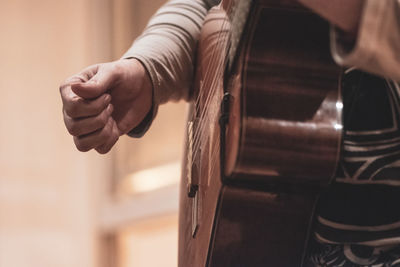 Midsection of person playing guitar