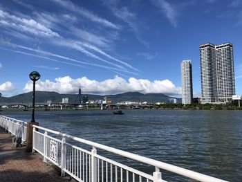 River by city buildings against sky