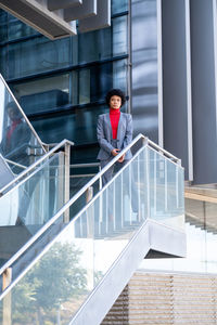 A young african-american businesswoman wearing a red turtleneck and a suit in a business building