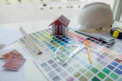 High angle view of color swatch with model home and hardhat on table