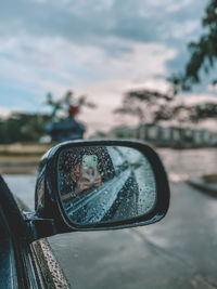 Close-up of reflection on side-view mirror of car
