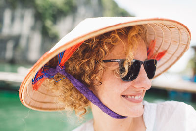 Close-up of smiling woman wearing sunglasses and hat
