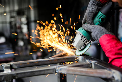 Welder used grinding stone on steel in factory with sparks, welding process at the industrial work