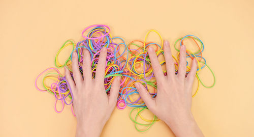 Cropped hand of woman with heart shape on pink background