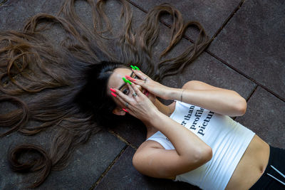 Lifestyle portrait of a beautiful woman with long hair resting on the floor