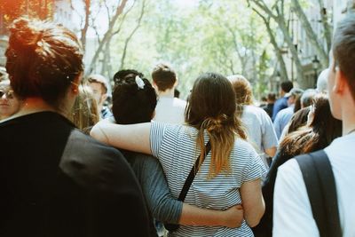 Rear view of people standing against blurred background