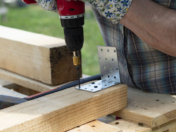 Midsection of man working on wooden plank
