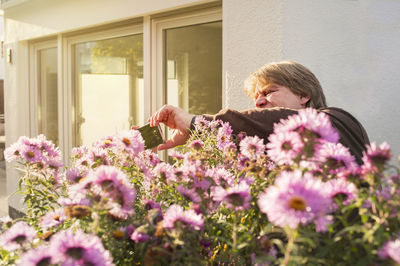Man photographing flowering plants