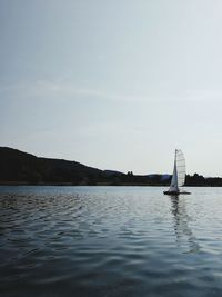 Sailboats sailing in sea against sky