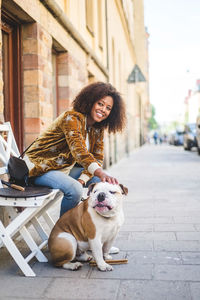 Full length of smiling young woman in city