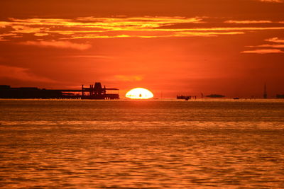 Scenic view of sea against orange sky