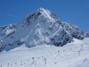 Scenic view of snowcapped mountains against clear blue sky