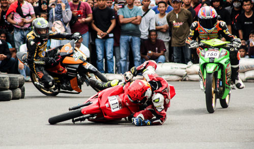 Group of people riding motorcycle on road