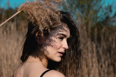 Portrait of young woman against plants