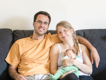 Happy friends sitting on sofa