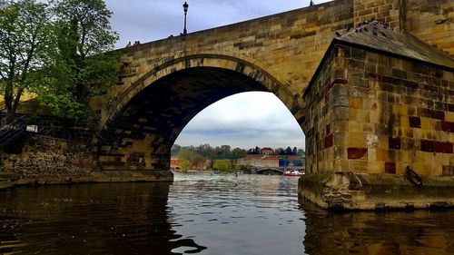 Arch bridge over river against sky