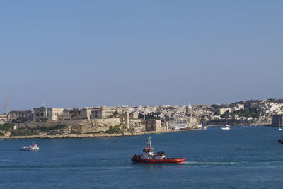 Boat sailing on sea against clear sky