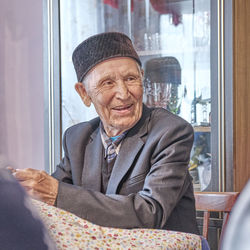 Portrait of smiling man sitting in glass window