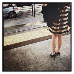 Low section of woman standing on sidewalk