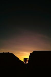 Low angle view of silhouette building against sky at sunset