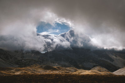 Scenic view of mountains against cloudy sky