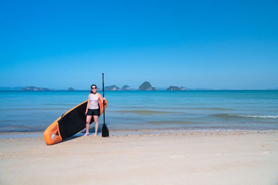 Full length of man on beach against clear sky