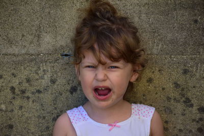 Portrait of girl against wall