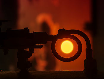 Close-up of silhouette fire against orange sky