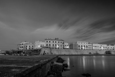 Buildings by sea against sky in city