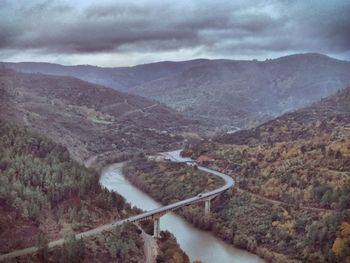 High angle view of river amidst mountains against sky