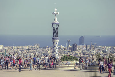 People on street by buildings against sky