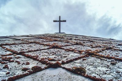 Low angle view of cross on temple against sky