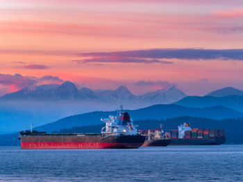 Ship in sea against sky during sunset