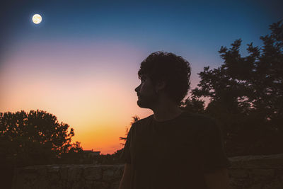 Silhouette man looking at sunset