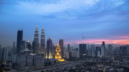 Skyscrapers in city against cloudy sky