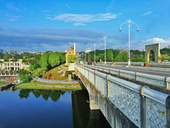 Bridge over river in city against sky