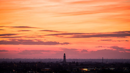 Silhouette buildings against sky during sunset