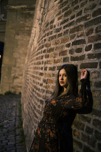 Portrait of woman standing against wall