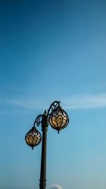 Low angle view of floodlight against blue sky