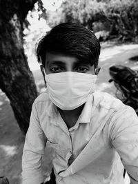 Portrait of young man wearing mask sitting outdoors