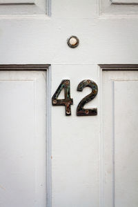 House number 42 on a white wooden front door in london 